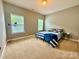 The bedroom features carpet, two bright windows, a queen bed with a blue striped comforter at 3678 Privette Rd # 349, Matthews, NC 28104