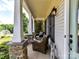 Relaxing front porch with stone pillars, wicker chairs, and inviting outdoor lighting at 3801 Creek Ridge Dr, Denver, NC 28037