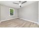 This light-filled bedroom features a modern ceiling fan, neutral walls, and wood-look flooring at 3920 Admiral Ave, Charlotte, NC 28205
