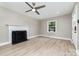 Cozy living room with a decorative fireplace, modern ceiling fan, and inviting natural light at 3920 Admiral Ave, Charlotte, NC 28205
