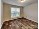 Bright bedroom with a large window, wood-look flooring, and natural light at 4006 Lawrence Daniel Dr, Matthews, NC 28104