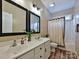 Bathroom with a double sink, wood flooring, large mirrors, and shower with curtain at 410 Deer Brush Ln, Waxhaw, NC 28173