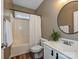 Bathroom featuring a shower/tub combo, vanity with sink, round mirror, and wood-look flooring at 410 Deer Brush Ln, Waxhaw, NC 28173