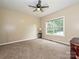 Empty bedroom featuring neutral walls, carpeted floors, a ceiling fan, and a window with wooded views at 410 Deer Brush Ln, Waxhaw, NC 28173