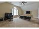 Large bonus room with a futon, desk, media center, ceiling fan, arched window, and carpet flooring at 410 Deer Brush Ln, Waxhaw, NC 28173