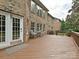 Exterior view of a deck featuring brick, a patio set, a white door, and lush trees at 410 Deer Brush Ln, Waxhaw, NC 28173