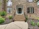 Charming brick home entrance with decorative landscaping and elegant wrought iron railings at 410 Deer Brush Ln, Waxhaw, NC 28173