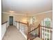 Carpeted hallway with wood railings overlooking the foyer below at 410 Deer Brush Ln, Waxhaw, NC 28173