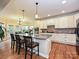 Well-lit kitchen with updated cabinetry, gray countertops, stainless appliances, and an island with barstool seating at 410 Deer Brush Ln, Waxhaw, NC 28173