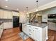 Large kitchen featuring stainless steel appliances, a center island, and access to the staircase at 410 Deer Brush Ln, Waxhaw, NC 28173