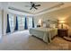 Main bedroom featuring tray ceilings, carpeted floors, and a sitting area with lots of natural light at 410 Deer Brush Ln, Waxhaw, NC 28173