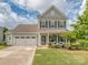 Charming two-story home featuring a well-manicured lawn, two-car garage, and inviting front porch at 4205 Bent Green Ln, Monroe, NC 28112