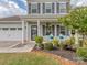 Close-up view of the charming front porch, featuring decorative chairs and manicured landscaping at 4205 Bent Green Ln, Monroe, NC 28112