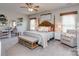 Cozy main bedroom with a four-poster bed, sitting chair, desk, and natural light at 4205 Bent Green Ln, Monroe, NC 28112