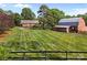 Expansive backyard features a residence and barn, with lush, striped lawns and a classic wooden fence at 425 Troutman Rd, Rockwell, NC 28138
