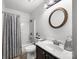 Clean bathroom featuring a shower-tub combo, white sink, and round mirror at 425 Troutman Rd, Rockwell, NC 28138