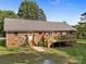 Charming brick home featuring a spacious deck, beautiful landscaping, and a welcoming entrance at 425 Troutman Rd, Rockwell, NC 28138