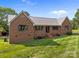 Well-maintained brick home featuring a durable metal roof, complemented by manicured landscaping for great curb appeal at 425 Troutman Rd, Rockwell, NC 28138