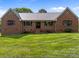 Charming brick home with a metal roof and a well-manicured lawn at 425 Troutman Rd, Rockwell, NC 28138