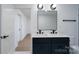 Bathroom featuring a double sink vanity, modern lighting, and updated finishes at 4500 Ridgeley Dr, Charlotte, NC 28208