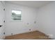 Bright bedroom with a window, white walls, wood-look flooring, and utility connections at 4500 Ridgeley Dr, Charlotte, NC 28208