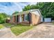 Single story brick home with black shutters, well-kept lawn, and a paved driveway at 4500 Ridgeley Dr, Charlotte, NC 28208