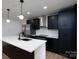 Modern kitchen with stainless steel refrigerator and black cabinetry at 4500 Ridgeley Dr, Charlotte, NC 28208