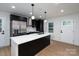Modern kitchen featuring black cabinets, stainless steel appliances, and a large island with a white countertop at 4500 Ridgeley Dr, Charlotte, NC 28208