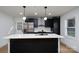 Modern kitchen featuring black cabinets, stainless steel appliances, and a large island at 4500 Ridgeley Dr, Charlotte, NC 28208