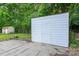 View of the white shed surrounded by greenery and a glimpse of a smaller shed in the background at 4500 Ridgeley Dr, Charlotte, NC 28208