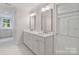 Bathroom featuring double sinks with white cabinets, mirrors, and lighting at 4920 Parview S Dr, Charlotte, NC 28226
