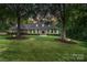 Stately brick home featuring a manicured lawn and mature trees, creating a welcoming curb appeal at 4920 Parview S Dr, Charlotte, NC 28226