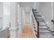 Bright hallway featuring hardwood floors, decorative columns, and a staircase with carpet runner at 4920 Parview S Dr, Charlotte, NC 28226