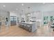 Spacious white kitchen with a large central island, stainless steel appliances, and modern pendant lighting at 4920 Parview S Dr, Charlotte, NC 28226