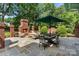 Outdoor patio featuring a brick fireplace, dining area, and comfortable seating, perfect for outdoor entertaining at 4920 Parview S Dr, Charlotte, NC 28226