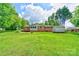 Lush backyard featuring a well-maintained lawn, brick house, storage shed, and mature trees for added privacy at 504 Forest Ridge Dr, Shelby, NC 28152