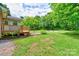 Spacious backyard features a wooden deck, lush lawn, and a charming firepit area surrounded by mature trees at 504 Forest Ridge Dr, Shelby, NC 28152