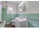 Bathroom features green tiling, wood-style floors, and modern fixtures at 504 Forest Ridge Dr, Shelby, NC 28152
