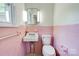Retro-style pink bathroom with a sink, toilet, and tiled walls at 504 Forest Ridge Dr, Shelby, NC 28152