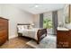 Serene bedroom featuring a queen-sized bed, wood floors, natural light, and tasteful decor, perfect for relaxation at 5214 Polo Gate Blvd, Charlotte, NC 28216