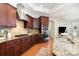Modern kitchen with stainless steel appliances, granite countertops, and dark wood cabinetry at 5214 Polo Gate Blvd, Charlotte, NC 28216