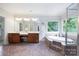 Bright bathroom with double vanity, soaking tub, and a large window with a view of the lush greenery outside at 552 Wyndham Ln, Marvin, NC 28173