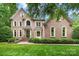 Charming two-story brick home featuring an arched entryway, bay window, and manicured landscaping at 552 Wyndham Ln, Marvin, NC 28173