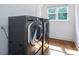 A bright laundry room featuring a gray washer and dryer set with a window for natural light at 552 Wyndham Ln, Marvin, NC 28173