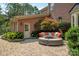 Brick home showcases an outdoor patio featuring a charming seating area with orange pillows and a lush green landscape at 552 Wyndham Ln, Marvin, NC 28173