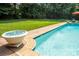 A pristine pool with water features is surrounded by lush greenery and provides a refreshing backyard retreat at 552 Wyndham Ln, Marvin, NC 28173