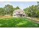 Expansive backyard with lush green lawn, mature trees, and a screened in porch overlooking the yard at 5601 Robinhood Rd, Charlotte, NC 28211