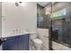 Modern bathroom featuring navy blue vanity, a shower with a glass enclosure and a marble tiled floor at 5601 Robinhood Rd, Charlotte, NC 28211
