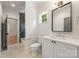 White bathroom with a window, gray tile accent wall, and a white vanity at 5601 Robinhood Rd, Charlotte, NC 28211