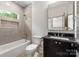 Neutral bathroom featuring a tiled shower and dark vanity at 5601 Robinhood Rd, Charlotte, NC 28211